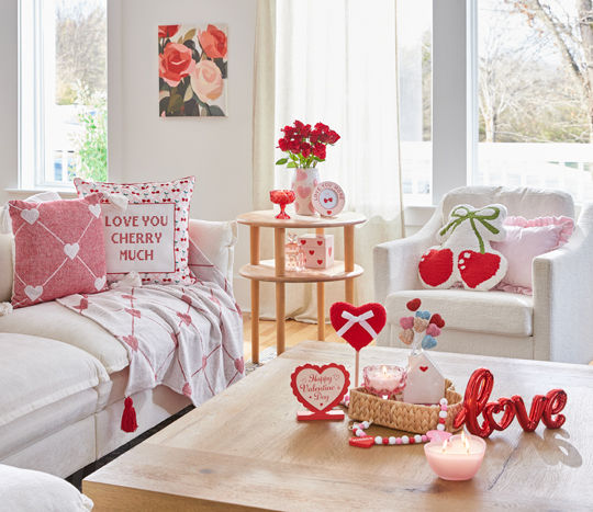 Living room decorated with pOpshelf Valentine's Day home decor pieces: heart and cherry pillows, roses wall art, heart candles, heart vase, and other valentine's day decor items.