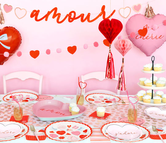 Parisian-inspired Valentine's Day party supplies: plates, napkins, fringed hanging honeycomb hearts, heart banners, balloons & more.