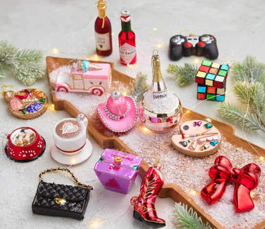 Glass novelty ornaments in a variety of designs: dog bowl, red bow, cowboy boot, pink cowboy hat, wine, rubik's cube & more.