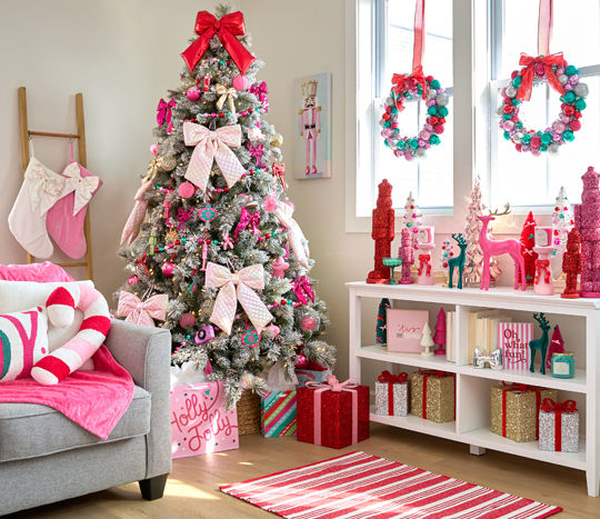 Room decorated with the Merry Merry pink, bows, and sparkly decor collection from pOpshelf: tree ornaments, wall art, pillows, throws, tinsel nutcrackers, bottlebrush trees, candles, ornament wreaths & garland.