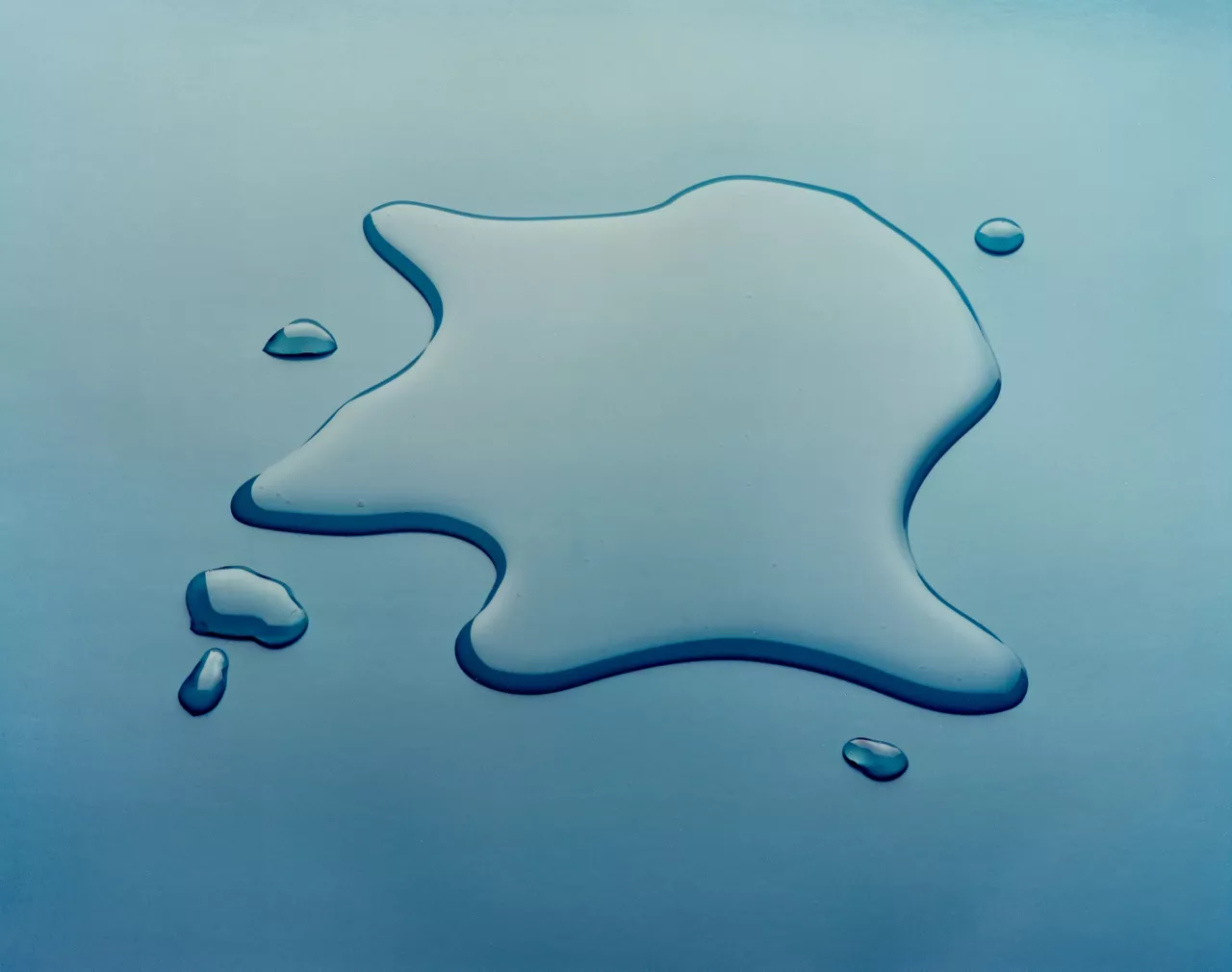 Large and small droplets of 561 Silicone Transformer Fluid on reflective "mirror" surface.