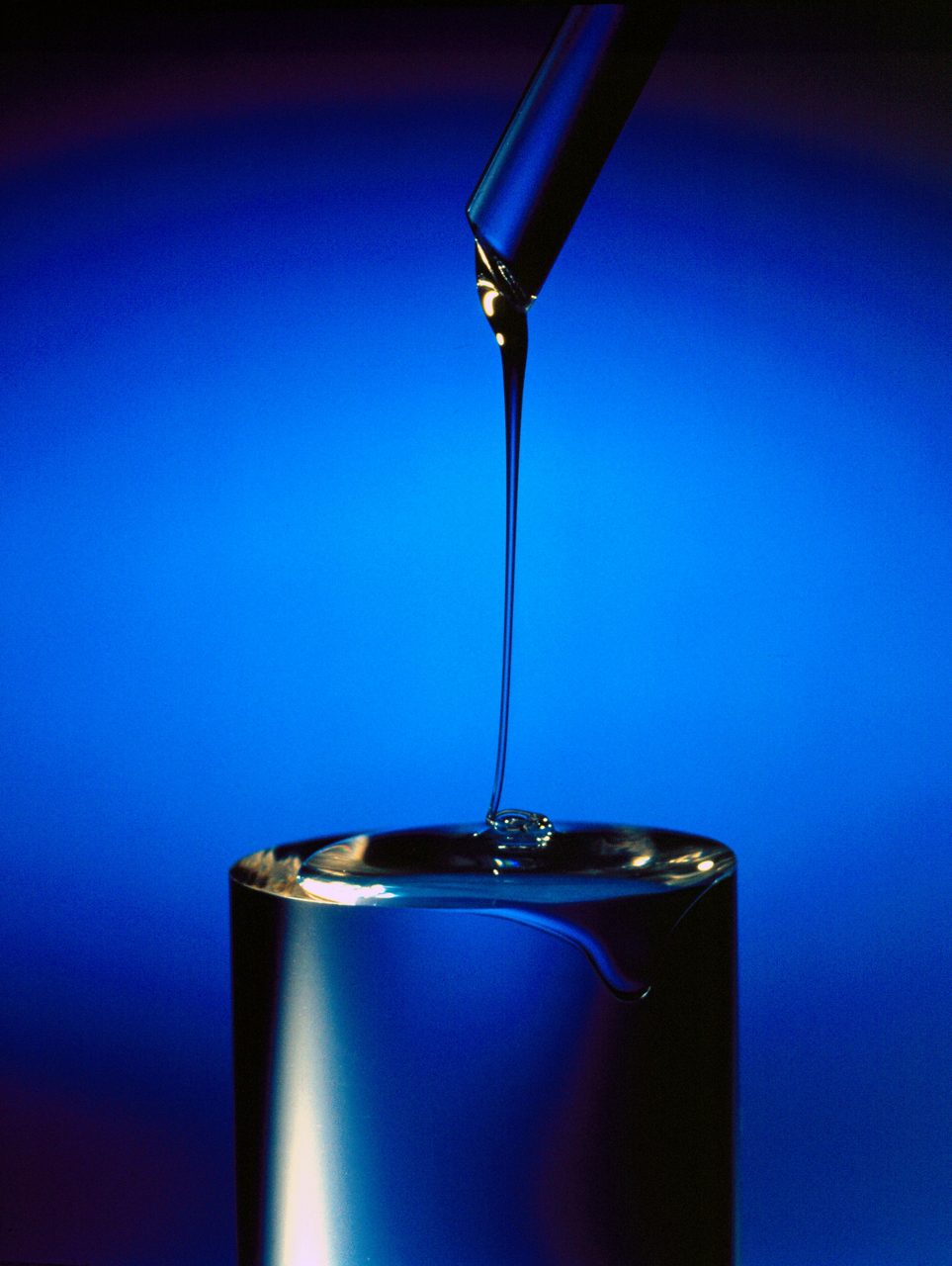 Liquid Silicone Rubber (LSR) pouring from a plastic tube onto a cylinder