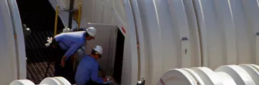 Two men inspecting storage drums at the Carrollton Plant.