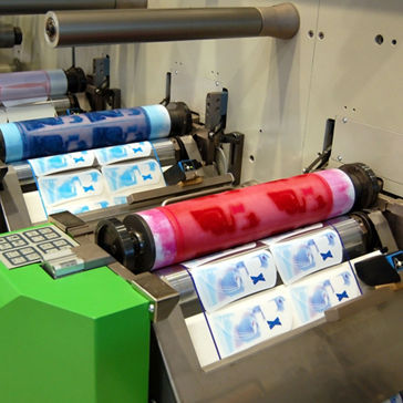 UV flexo press for printing labels. Flexography (also called surface printing), often abbreviated to flexo, is a method of printing most commonly used for packaging (labels, tape, bags, boxes, banners). A flexographic print is made by creating a positive mirrored master of the required images as a 3D relief in a rubber or polymer material. / Dreamstime Image #5337142