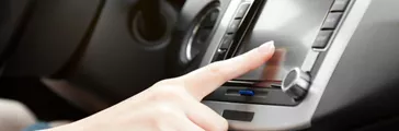 Close-up of finger touching car’s dashboard 