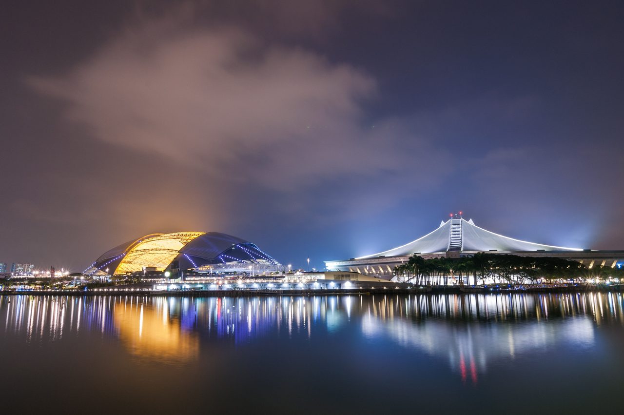 Singapore's new National Stadium at night after a rainstorm with reflections in the water. / Shutterstock Image #384120019