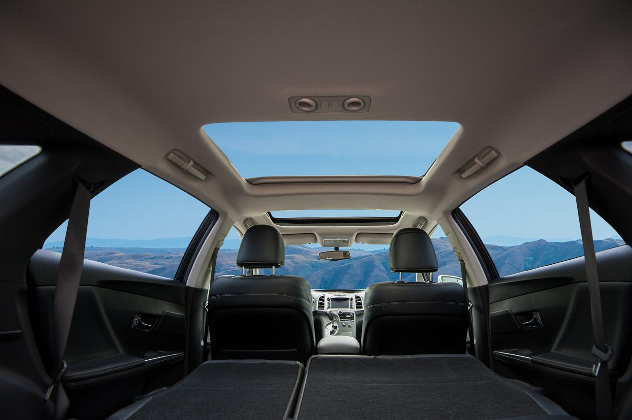 Interior del automóvil de cuero negro con luz ambiental violeta.