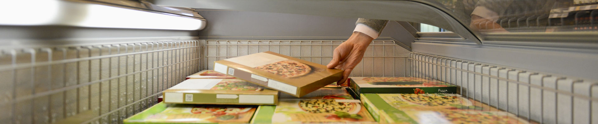 Homem selecionando uma pizza congelada de uma caixa de freezer em um supermercado e AFFINITY™ GA logo