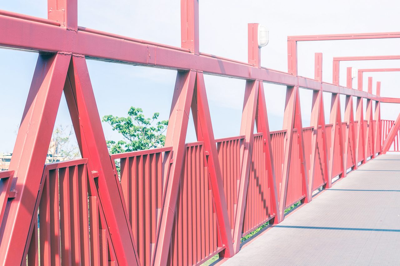 Iron truss footbridge painted in vivid red