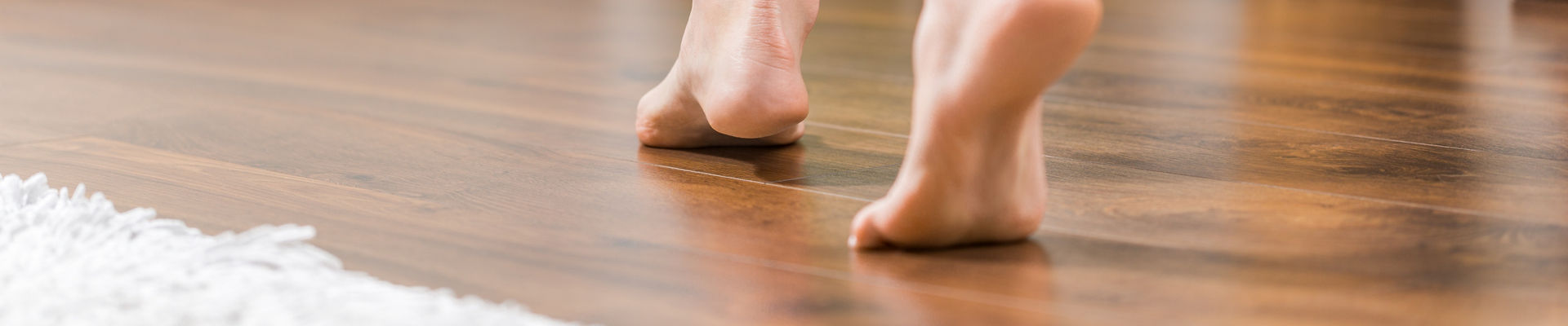 Person walking barefoot on floorboards