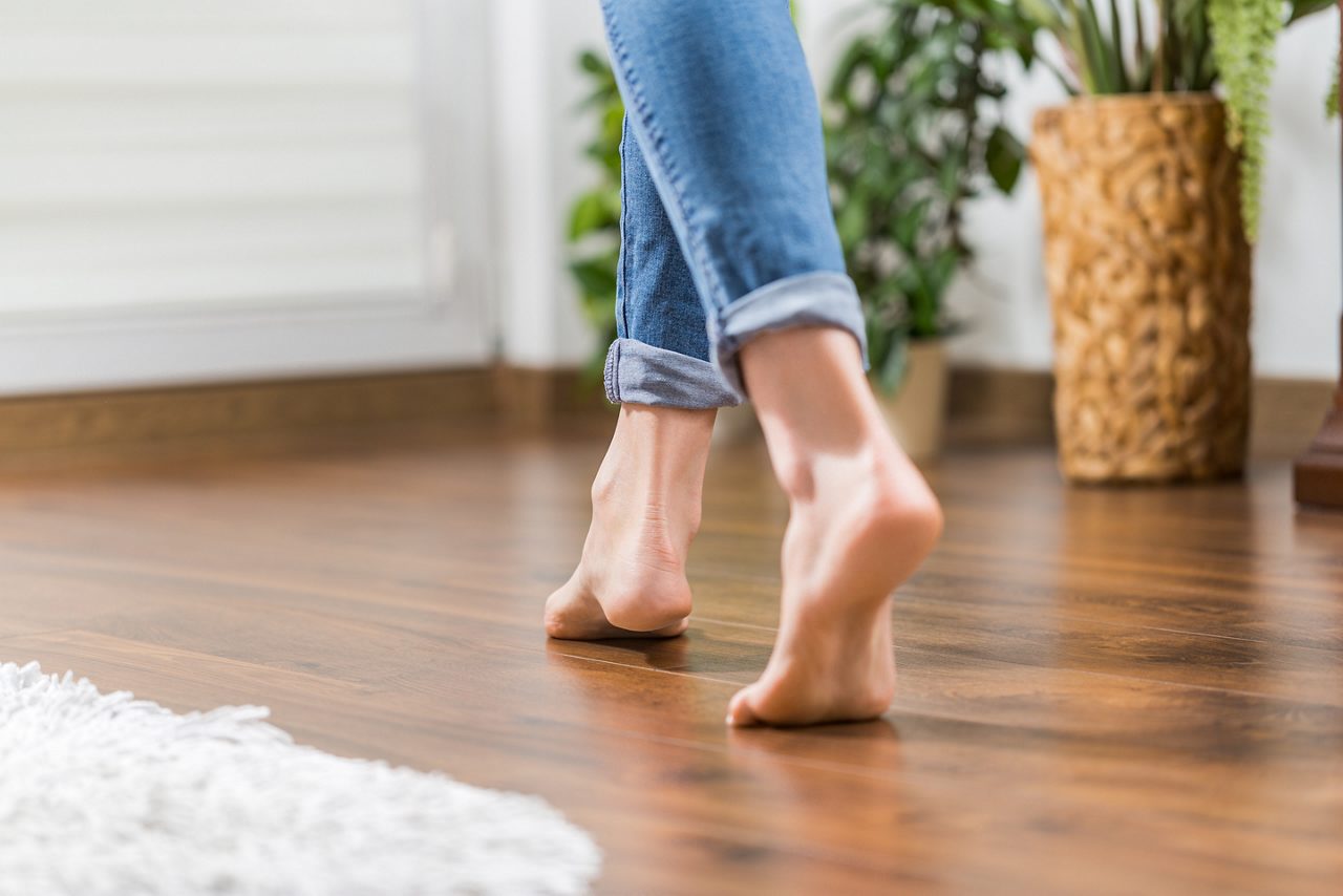 Person walking barefoot on floorboards
