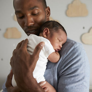 Father Holding Newborn Baby Son In Nursery