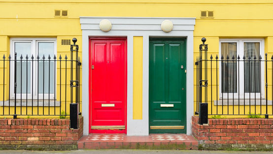 Yellow building with red and green doors