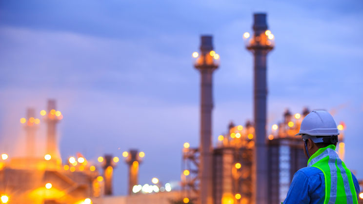 Trabajador mirando la refinería de petróleo