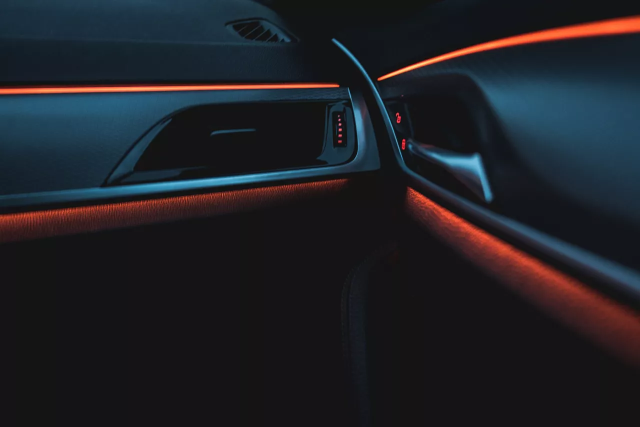 Car interior with ambient orange glow.