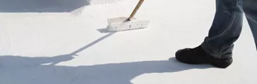 Person applying roof coating with a brush.