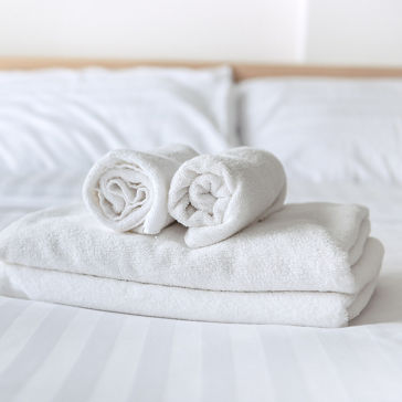 Clean white towels folded on a bed