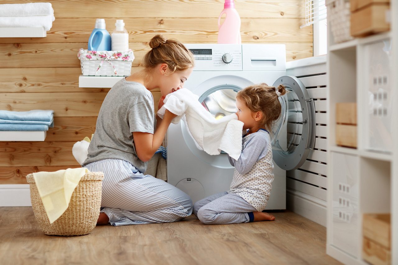 Mother and child smelling towel out of the dryer