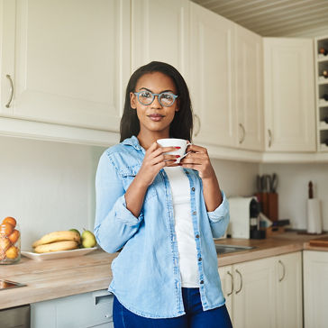 mujer pensando mientras bebe una taza de café recién hecho en su cocina en casa