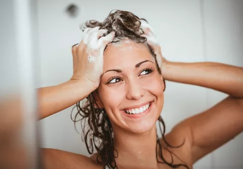 Woman washing her hair with natural shampoo 