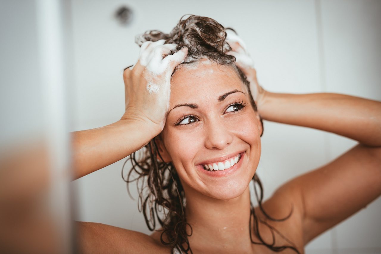 Woman washing her hair with natural shampoo 