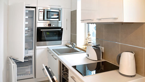 White modern kitchen with all appliance doors open