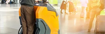 Man driving professional floor cleaning machine at airport or railway station