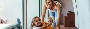 Mother pushing children sitting in laundry basket