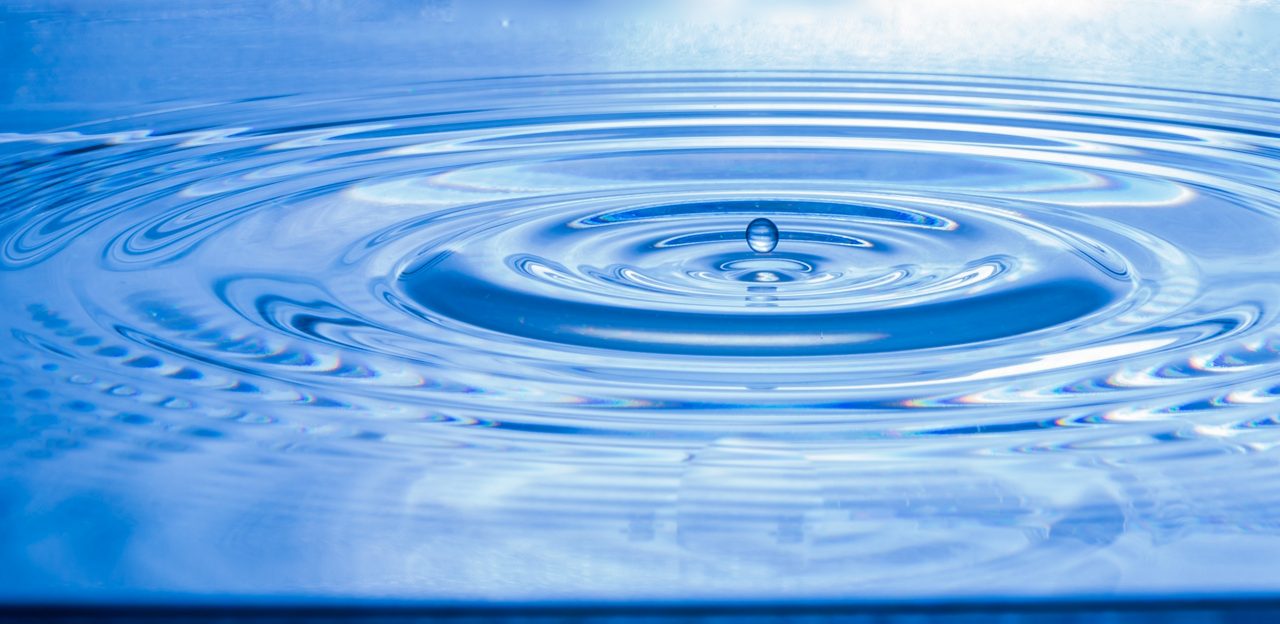 Water drop splashing in puddle