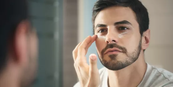Young Man Applying Anti-aging Lotion fot Skin Care