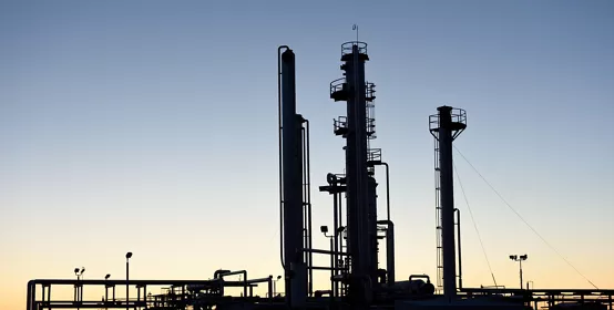Dawn silhouette of pipes and towers at a oil and gas industry processing facility in Wyoming, USA.