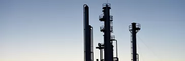 silhouette of pipes and towers at a oil and gas industry processing facility