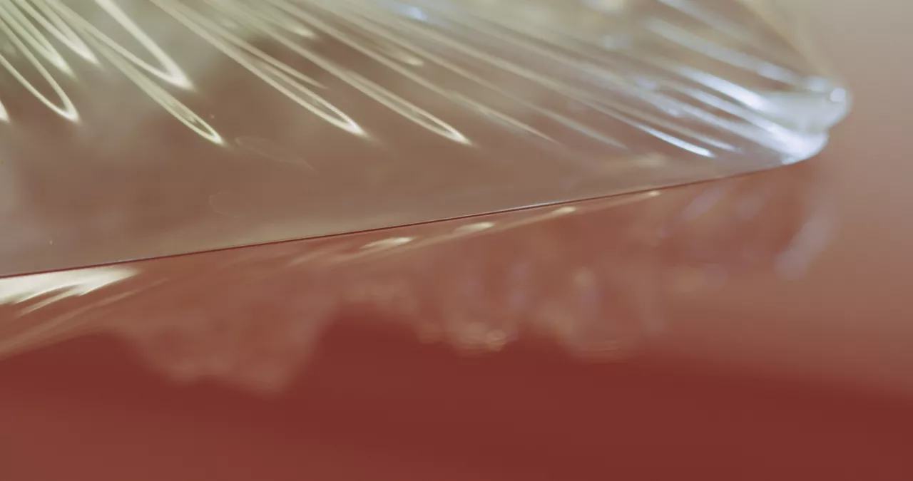 Closeup peeling off protective film from a car