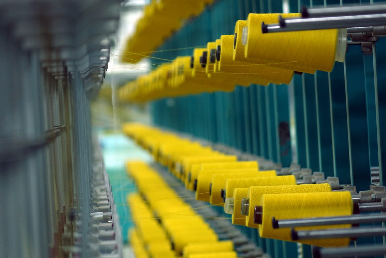 Spools of yellow thread on a spinning machine