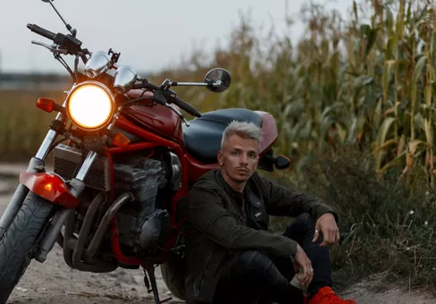 Fashionable Man Sitting Outside by His Motorcycle 