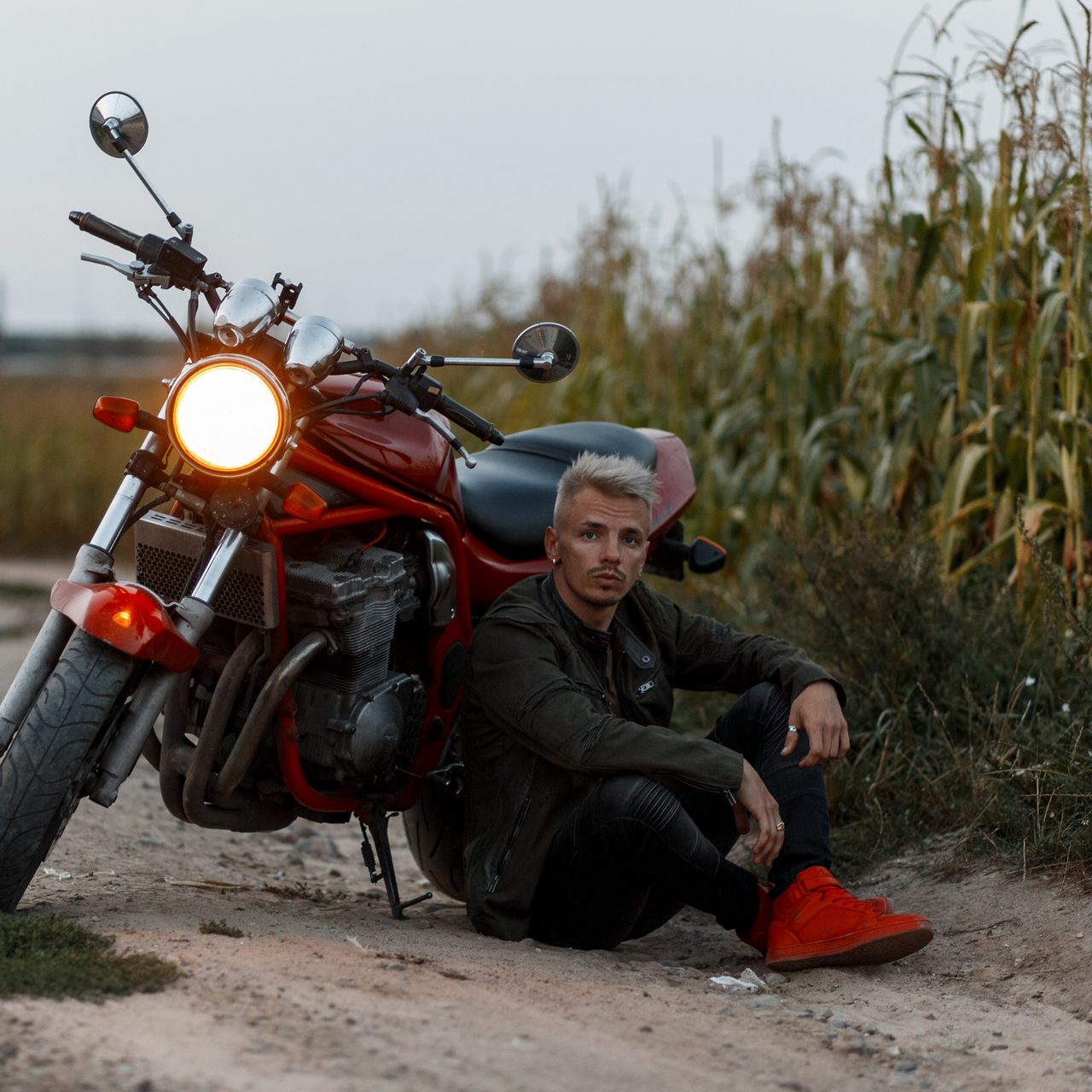 Fashionable Man Sitting Outside by His Motorcycle 