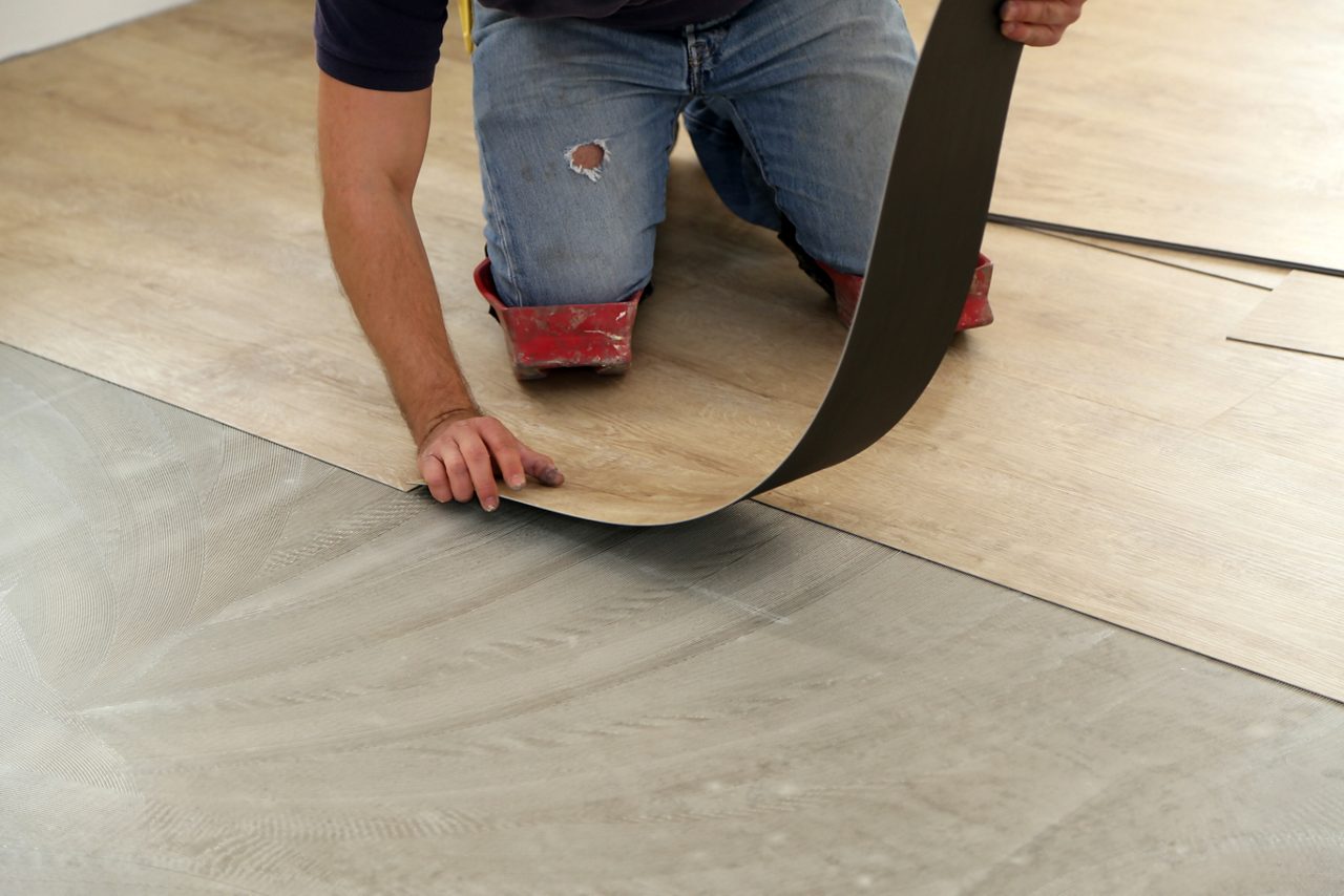 새로운 비닐 타일 바닥을 설치하는 작업자