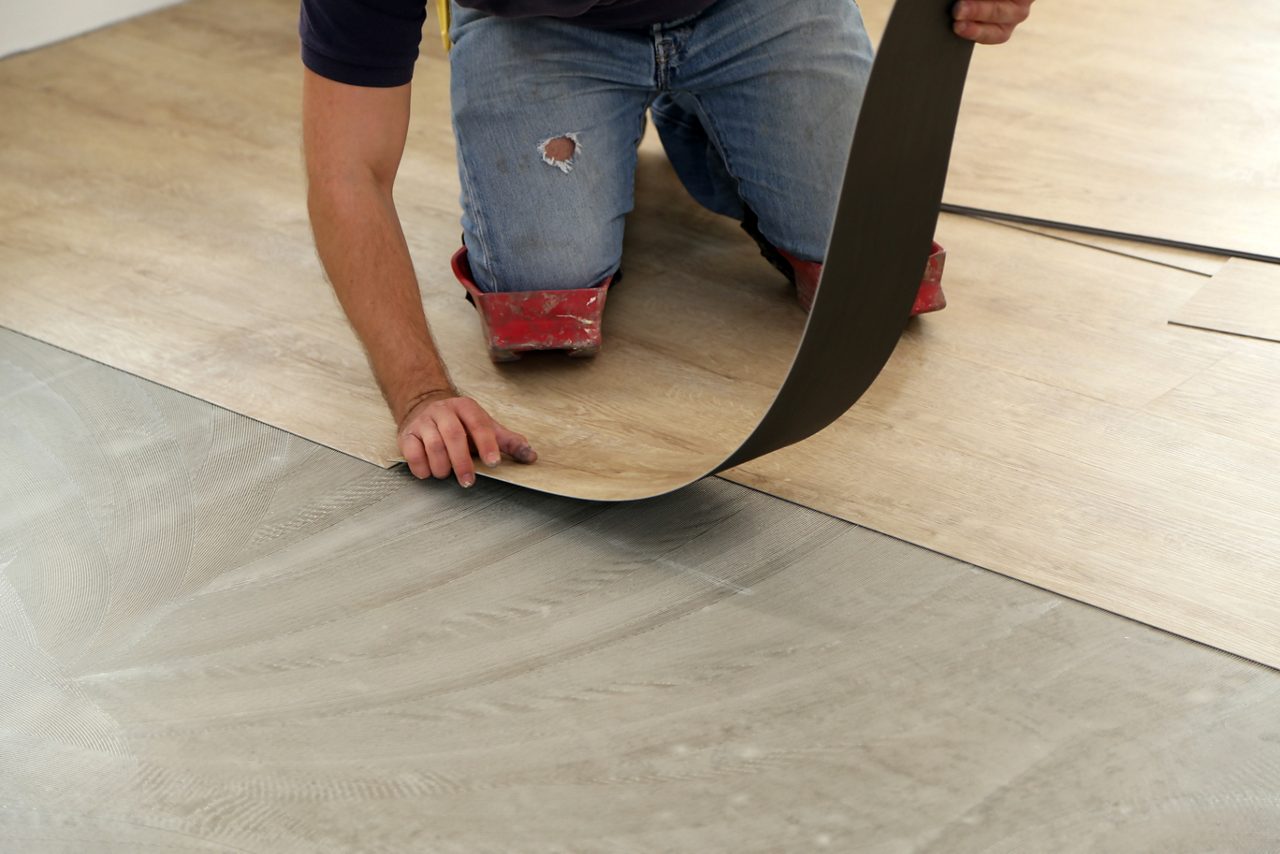 Worker installing new vinyl tile floor