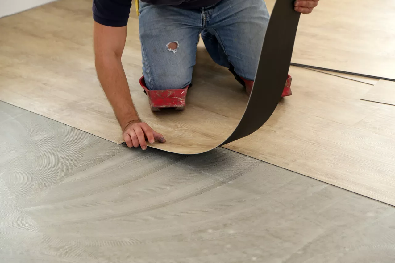 worker installing new vinyl tile floor