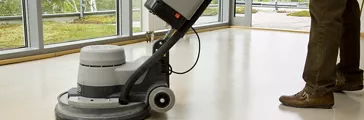 Person using a machine to clean the floor.