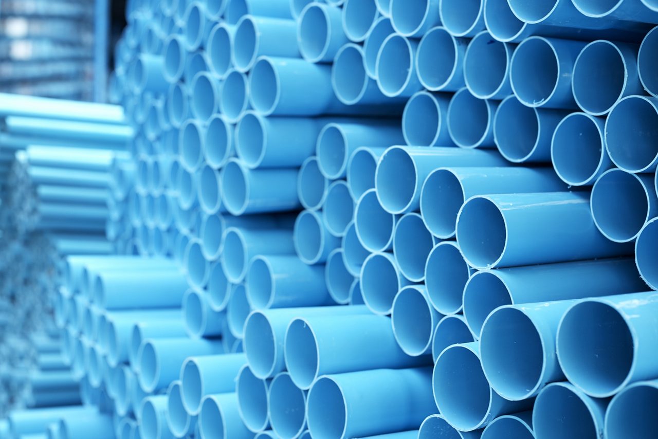 Blue PVC pipes stacked in a construction site