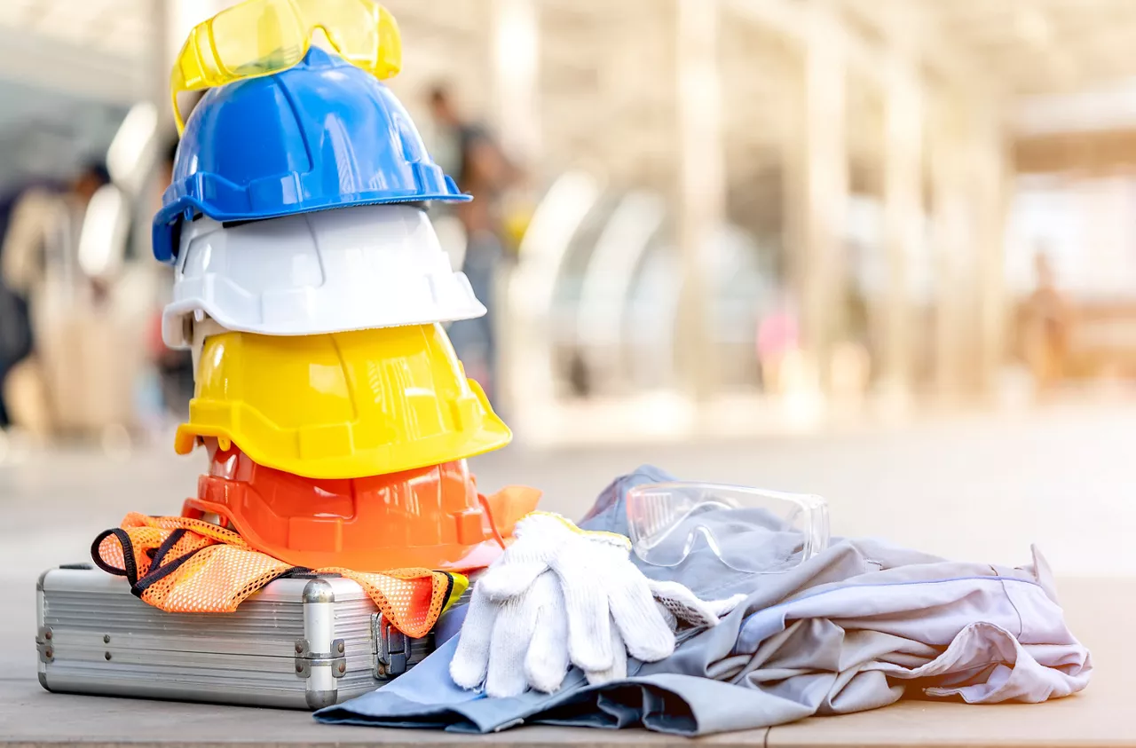 white, yellow and blue hard safety helmet hat and equipment for safety project of workman as engineer or worker, on concrete floor on construction site. Industrial Safety and Construction Standards