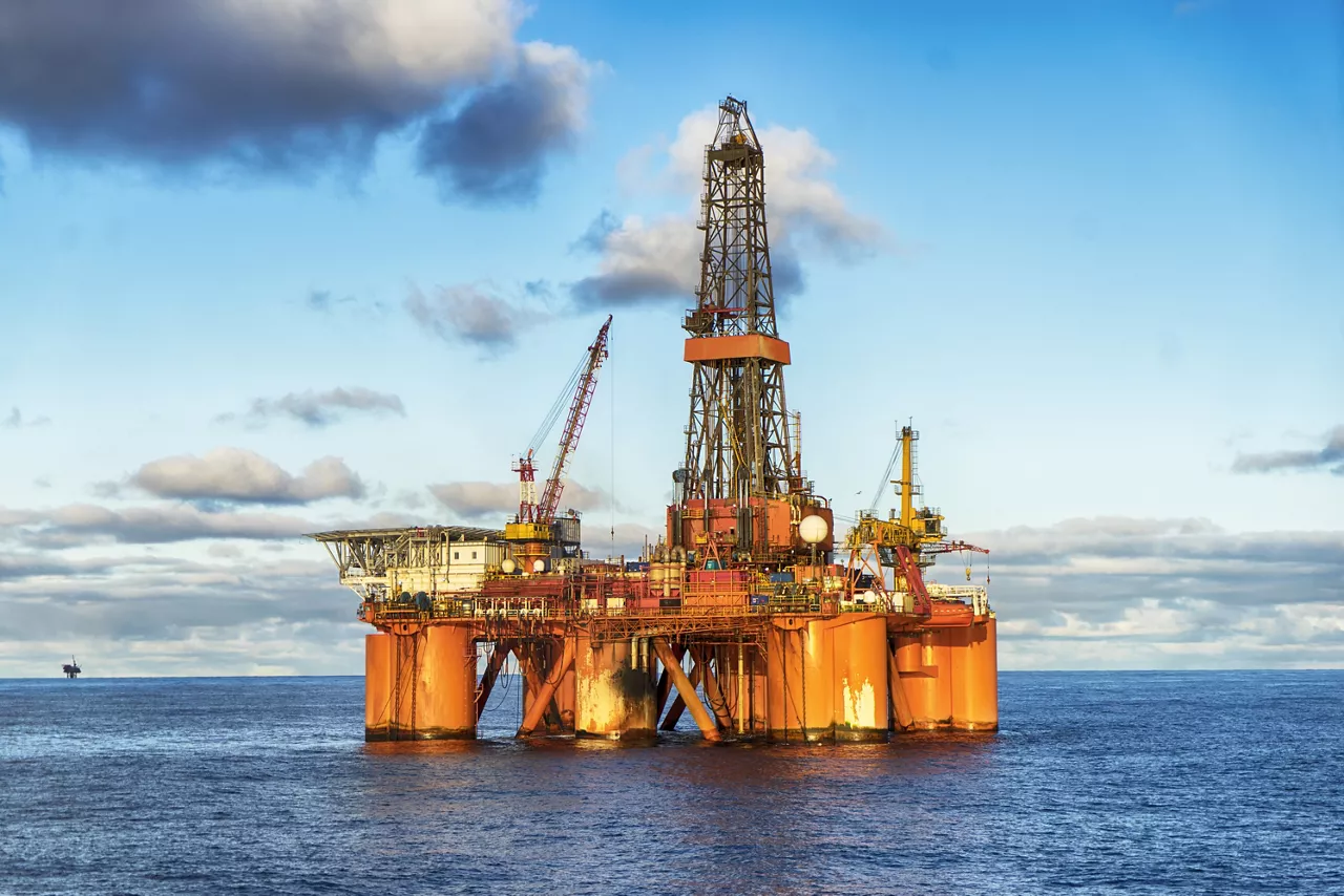 Oil rig in the sea lit up from below