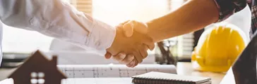 Client shaking hands with contractor after confirm blueprint to renovate house.