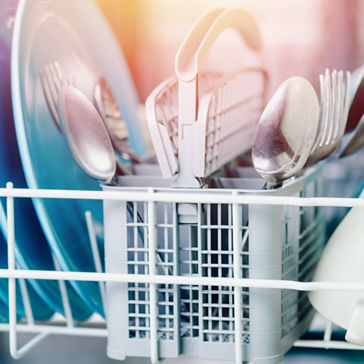 Abra el lavavajillas con platos y tenedores limpios y brillantes, cucharas, cubiertos 