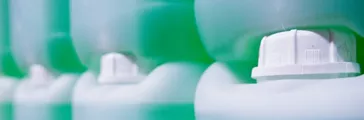 White drums with a green liquid inside them