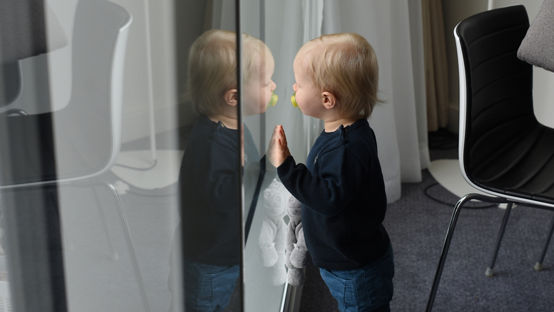 blond child in front of a window