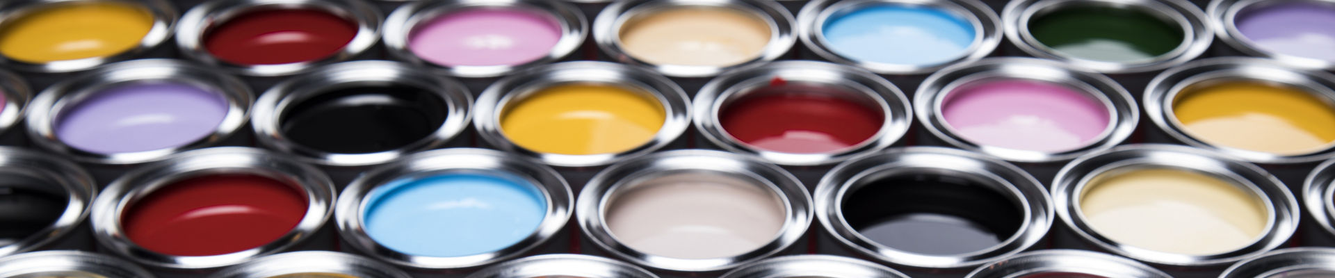 Grande variedade de latas de tinta abertas contendo várias cores de tinta