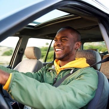 Retrato lateral de un hombre feliz conduciendo un automóvil