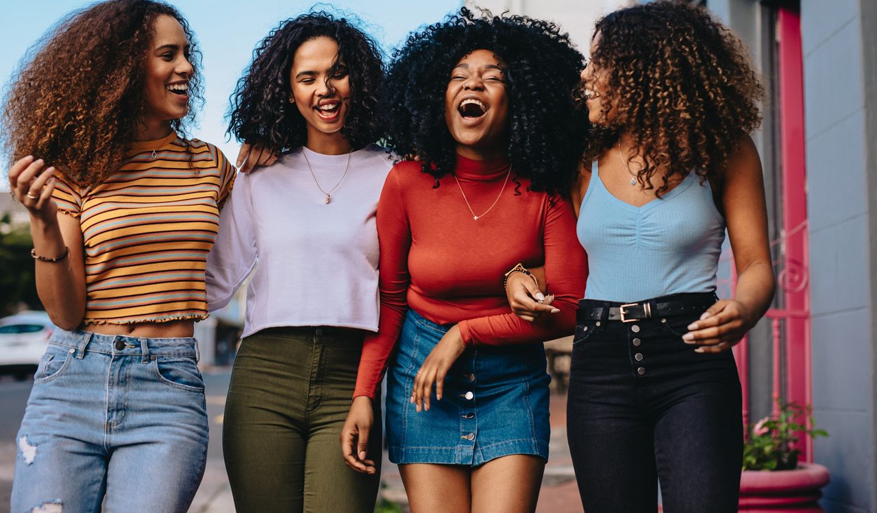 Group of female friends walking together outdoors in the city. Young women hanging out in the city.